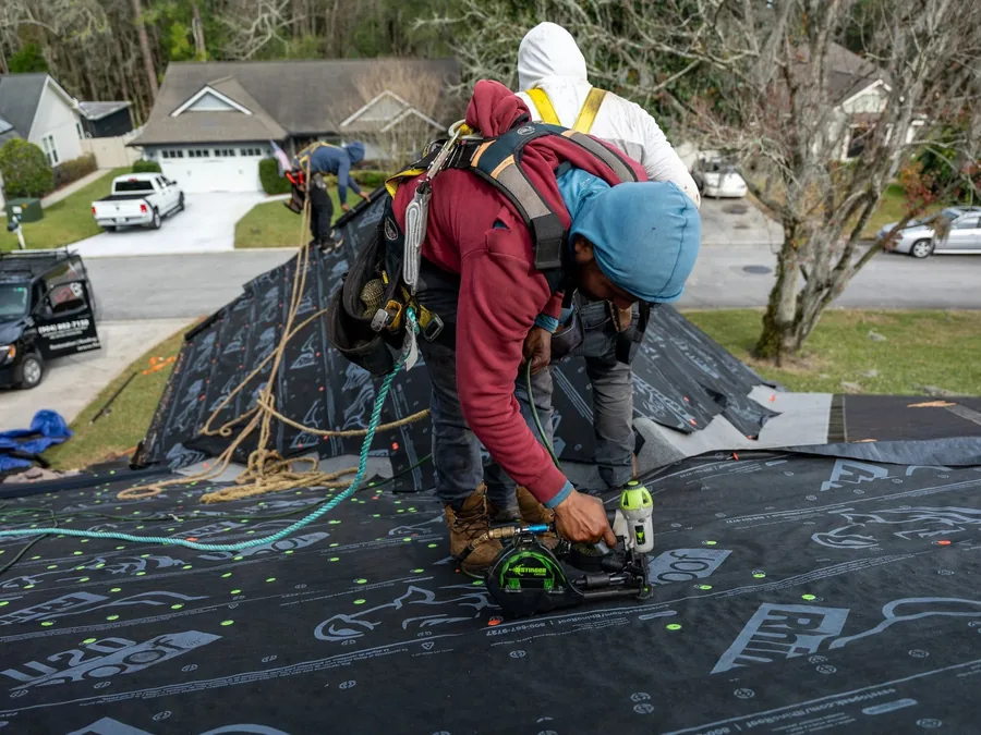Roofer using a nail gun